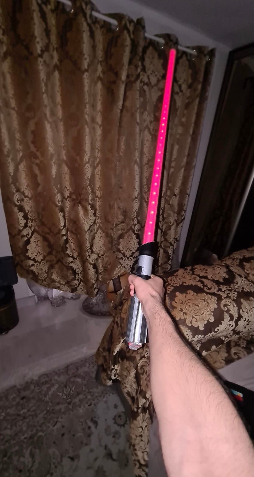 The finished lightsaber lit up in pink